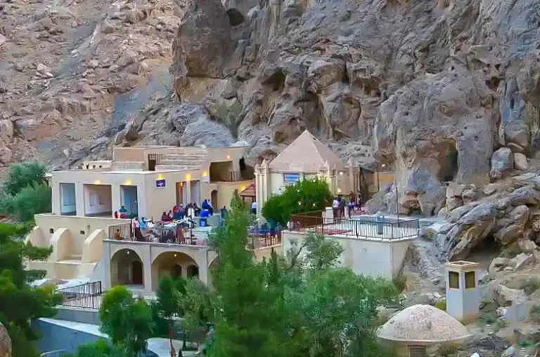 Distant view of Pir-e Narastaneh Zoroastrian shrine with pilgrims in Yazd, Iran